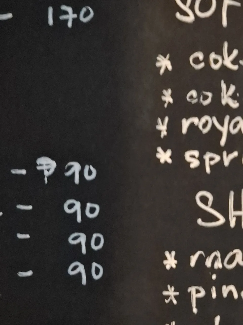 Kape Parola's handwritten chalkboard menu listing coffee, tea, juices, shakes, soft drinks and snacks with prices